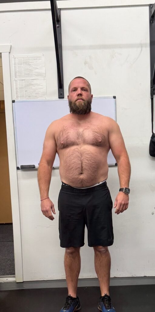 Man standing shirtless indoors before beginning fitness transformation